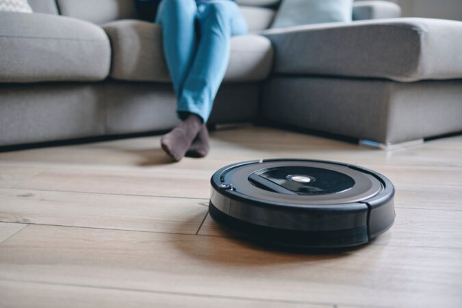 リビングの床を掃除するロボット掃除機(イメージ)